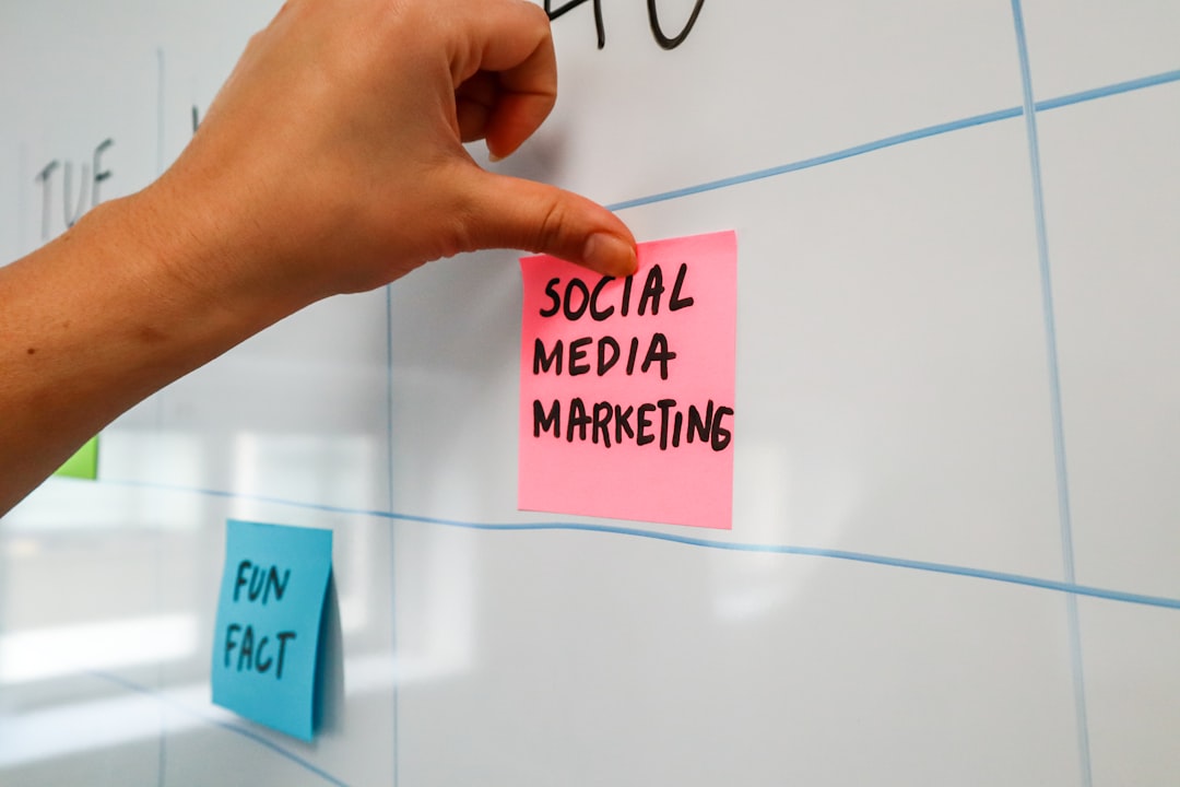 a hand is writing on a sticky note social media planning ai assistant content calendar marketing team