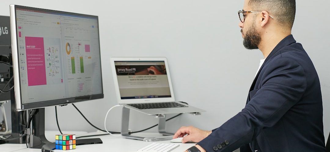 a man sitting at a desk with a laptop and a computer business software dashboard client management team workflow