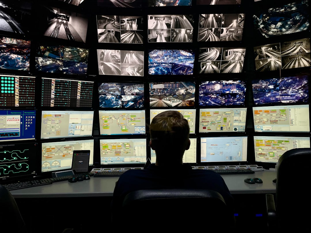 a man sitting in front of multiple monitors global security crisis monitoring threat alerts