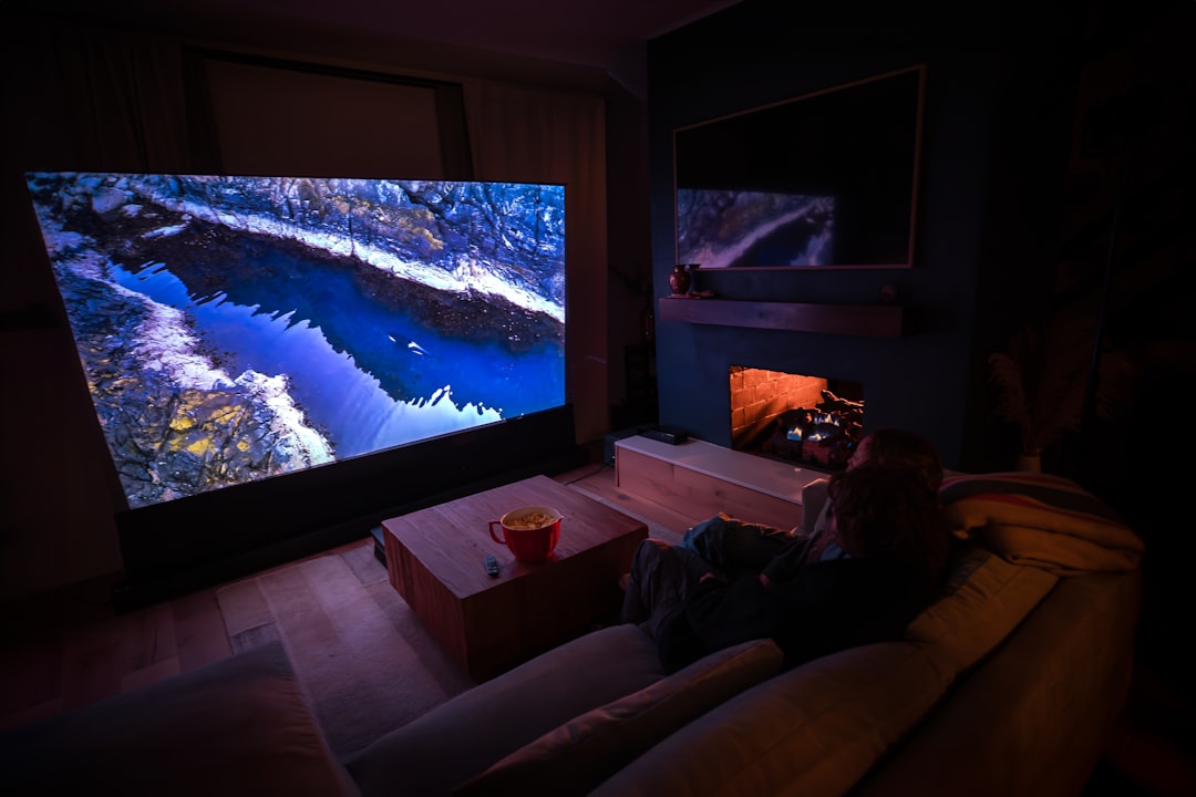 a person sitting on a couch in front of a flat screen tv home theater streaming apps movie night