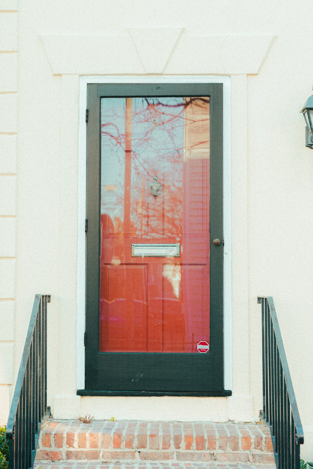 a red door and a black door on a white building doorbell camera view package delivery porch