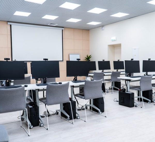 EMS Manager Review: Features & Competitors 7 a room filled with lots of computer monitors university classroom digital calendar scheduling dashboard