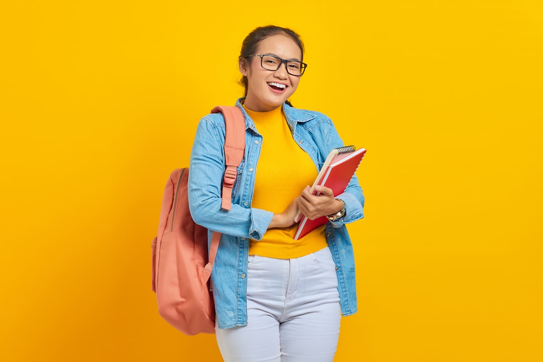 a woman with a backpack and a book smiling study notes quiz checklist smiling student
