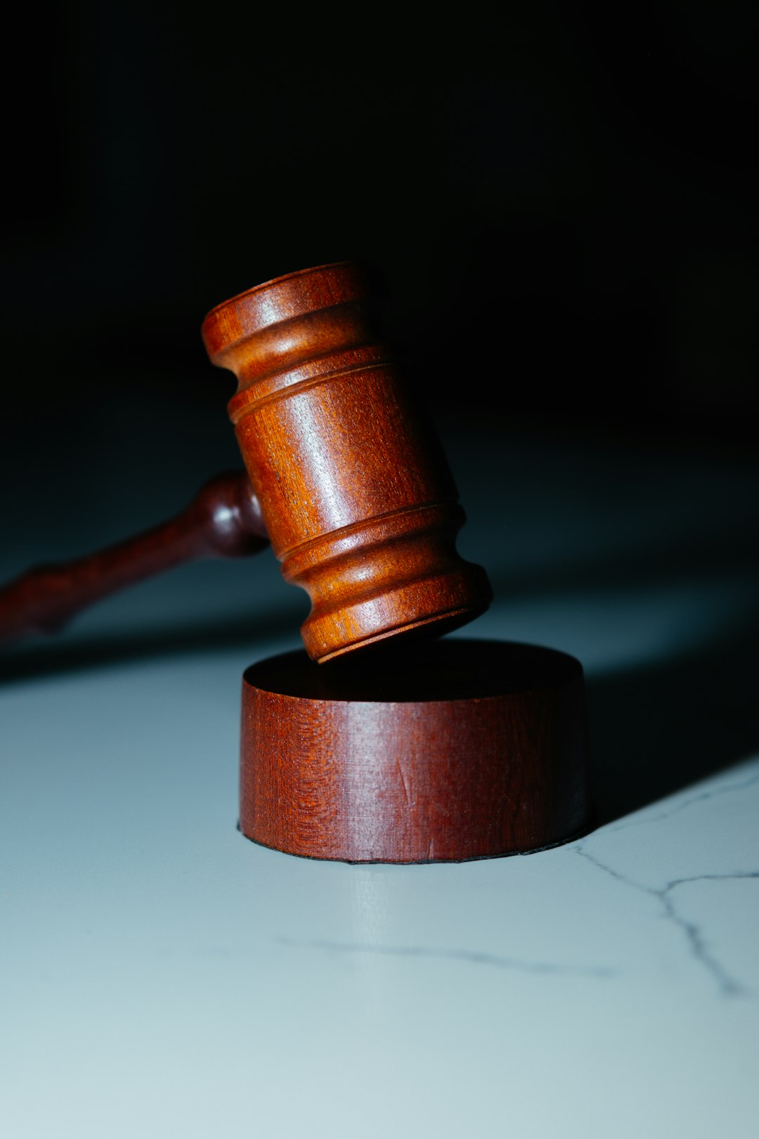 a wooden gaven sitting on top of a white counter copyright movie reel legal papers judge gavel
