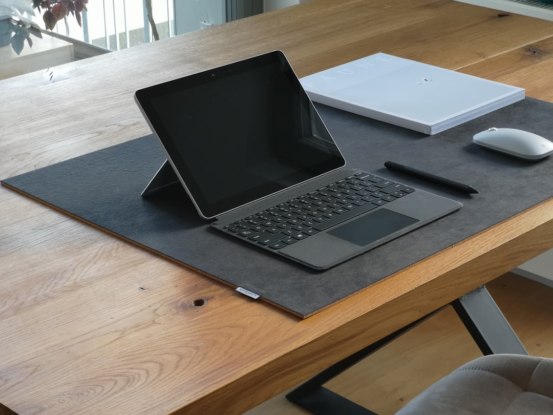 black and silver laptop computer on brown wooden table surface pen touchscreen drawing digital notes 1