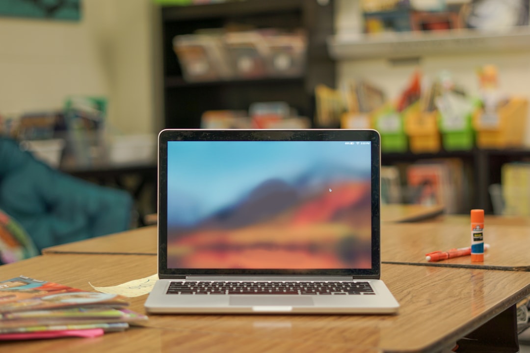 macbook pro on brown wooden table administrator laptop class schedule education software