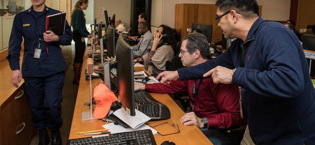 man in blue jacket using computer operations center dashboard cloud metrics team