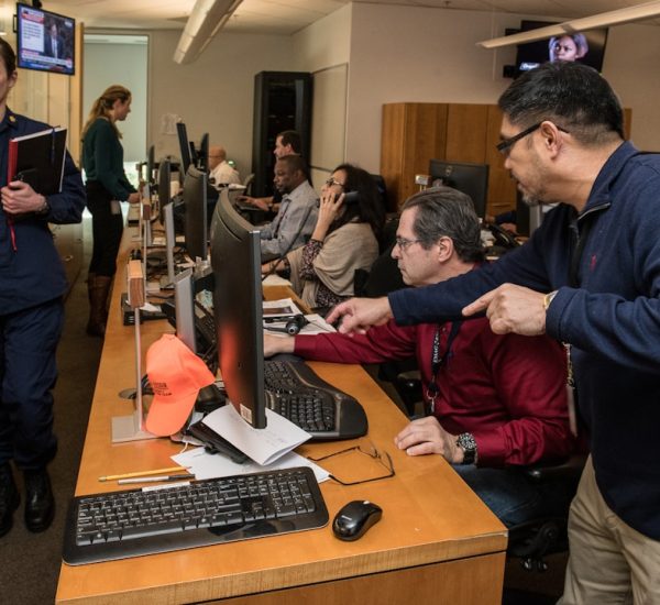 man in blue jacket using computer operations center dashboard cloud metrics team