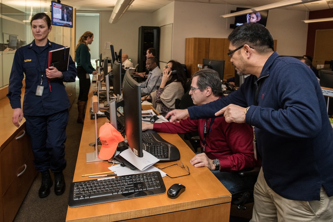 man in blue jacket using computer operations center dashboard cloud metrics team