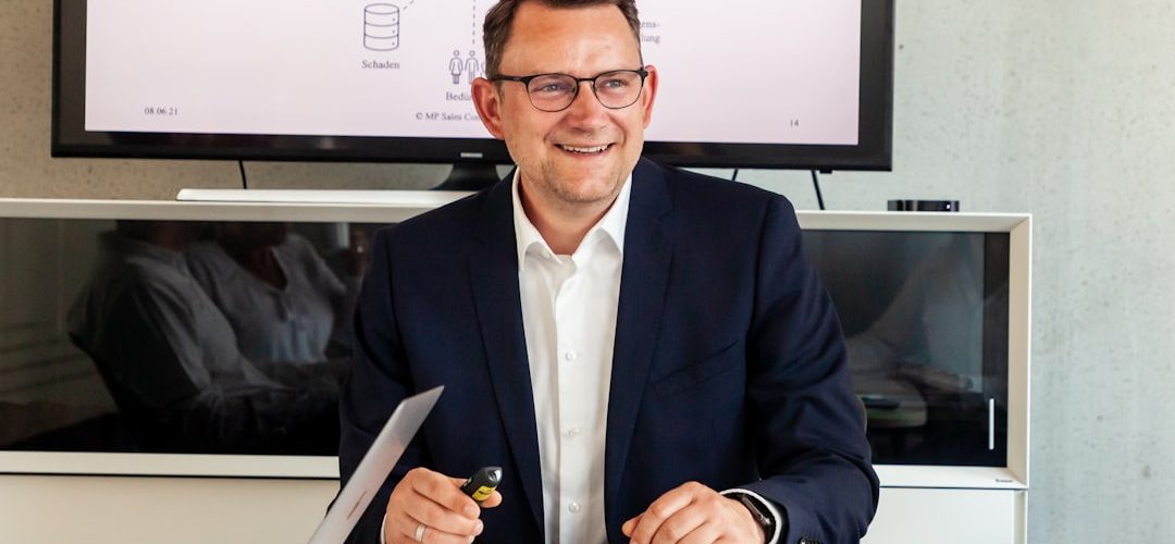 man in suit smiling in a meeting room crm dashboard customer notes sales team organized data 1