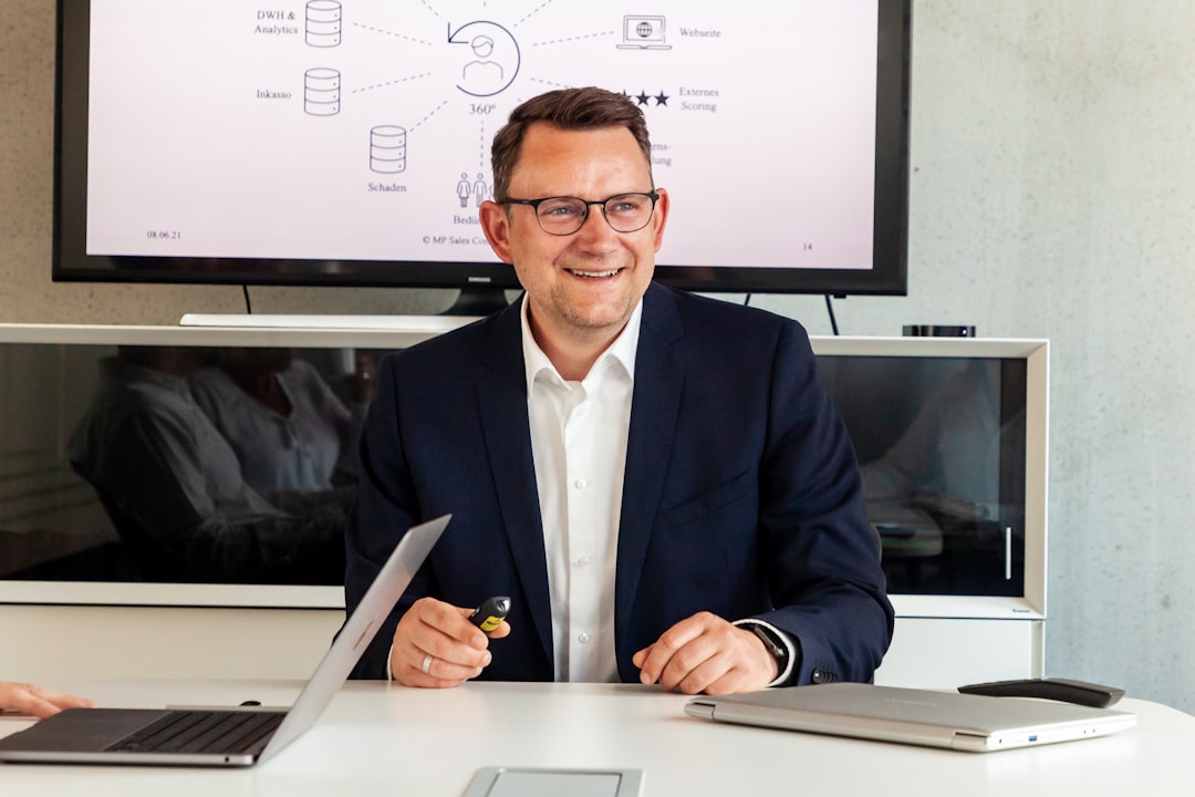man in suit smiling in a meeting room crm dashboard customer notes sales team organized data 2