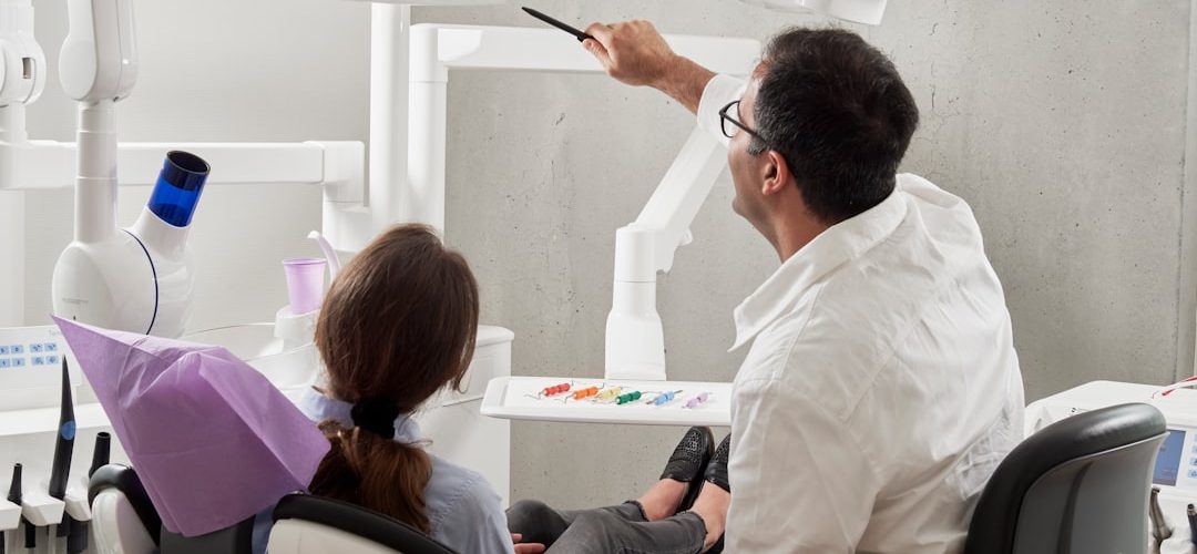 man in white dress shirt holding black pen digital dental scan intraoral scanner patient chair clinic technology