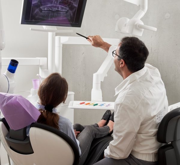 man in white dress shirt holding black pen digital dental scan intraoral scanner patient chair clinic technology