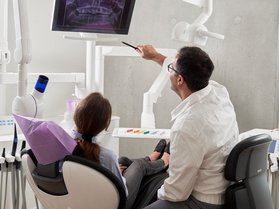 man in white dress shirt holding black pen digital dental scan intraoral scanner patient chair clinic technology