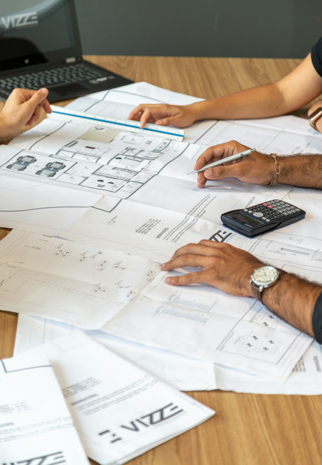 people reviewing architectural blueprints on desk professional services team project planning client reports