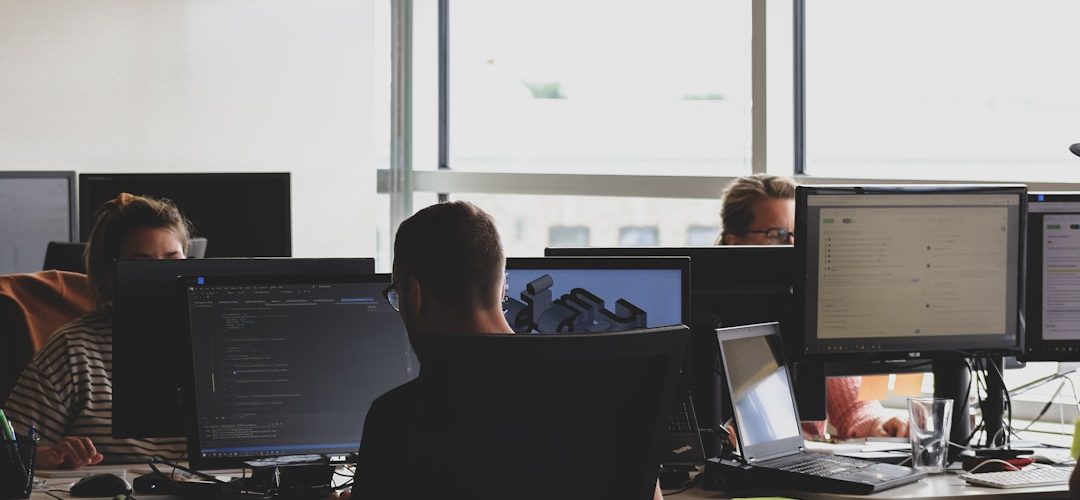 people sitting on chair in front of computer monitor business software dashboard client management team workflow