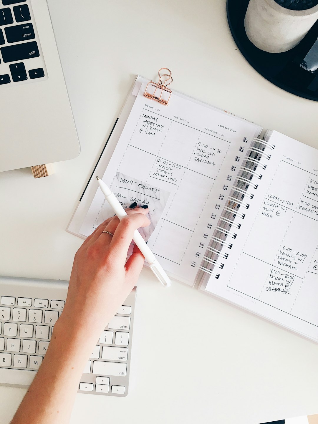 person holding notepad and pen flat lay photography blog income content calendar online business