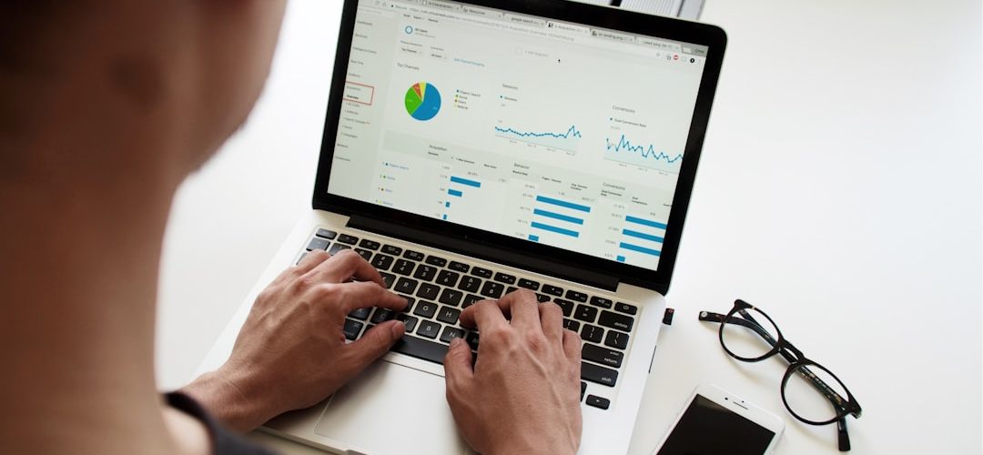 person using macbook pro technician reviewing email reports security charts client domains