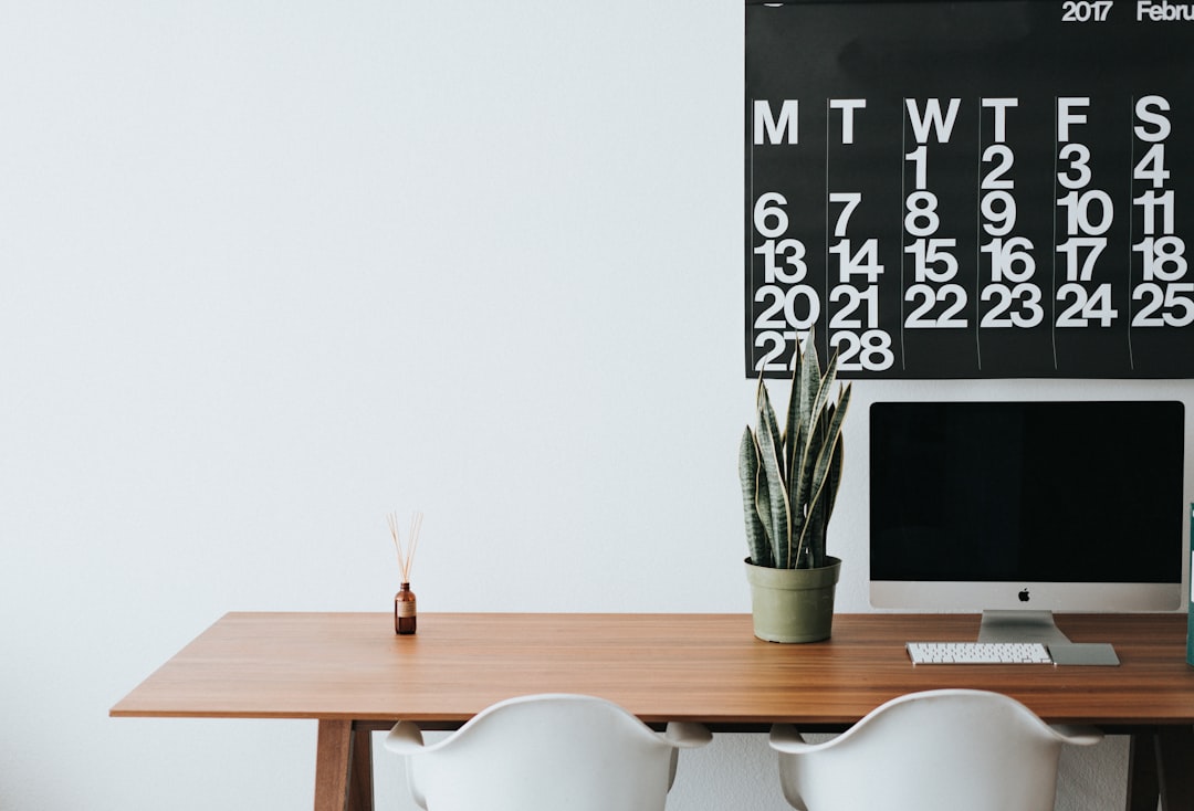 silver imac on brown wooden desk content calendar social media posts marketing strategy planning desk
