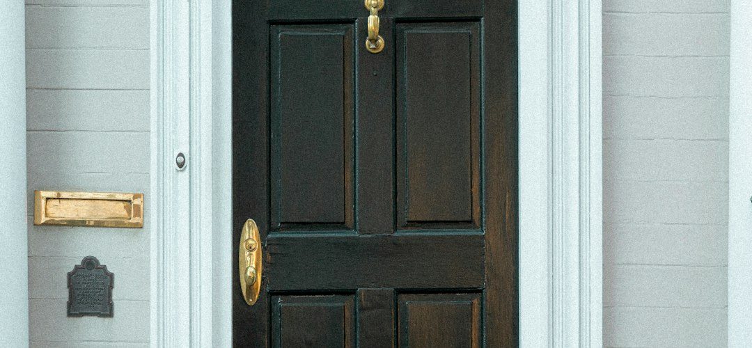 the front door of a white house with a black door doorbell camera view package delivery porch