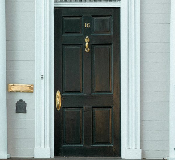 the front door of a white house with a black door doorbell camera view package delivery porch