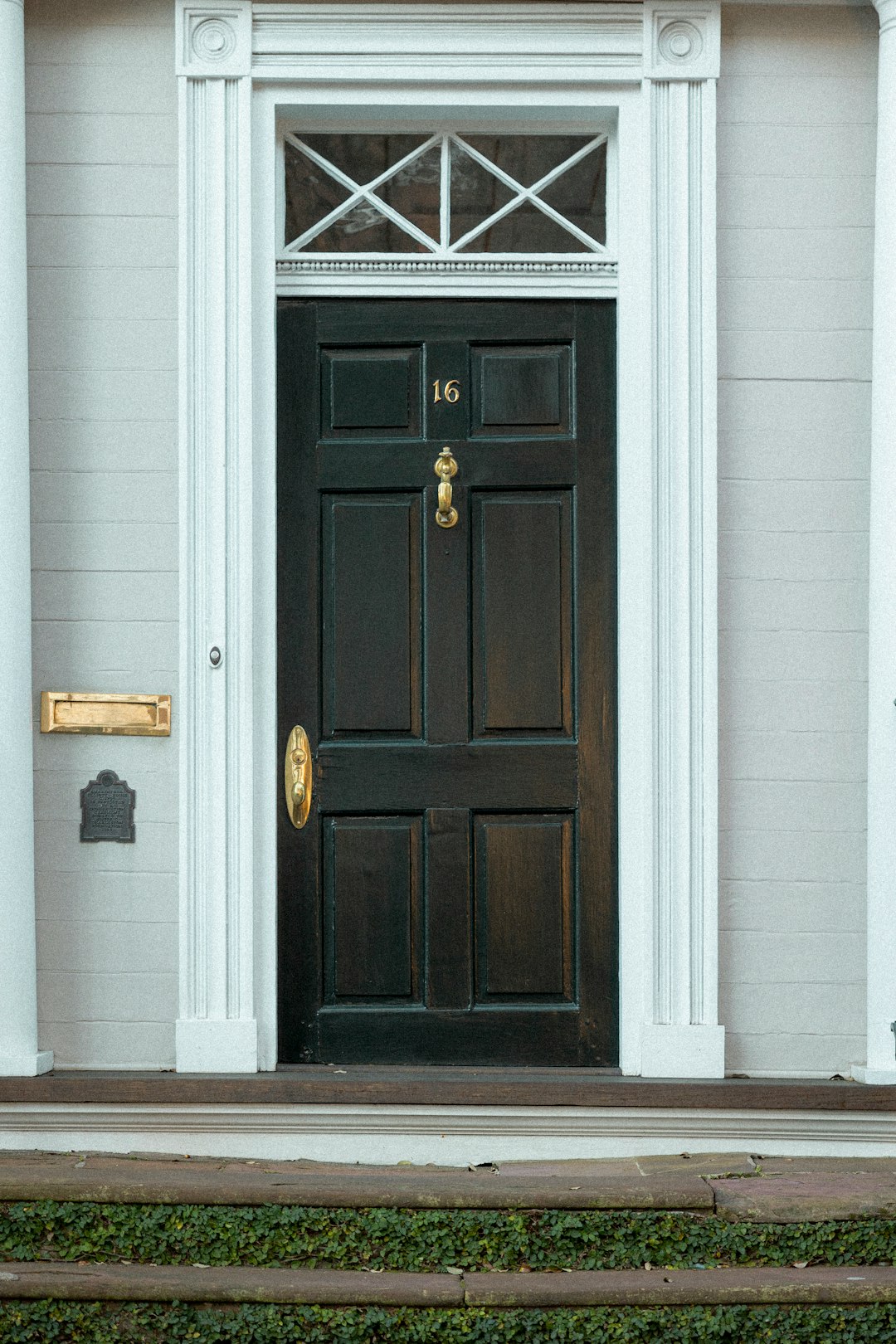the front door of a white house with a black door doorbell camera view package delivery porch