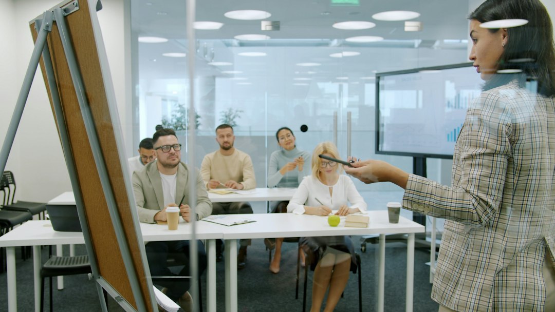 woman presenting to a group in a modern office teacher computer students laughing classroom screen