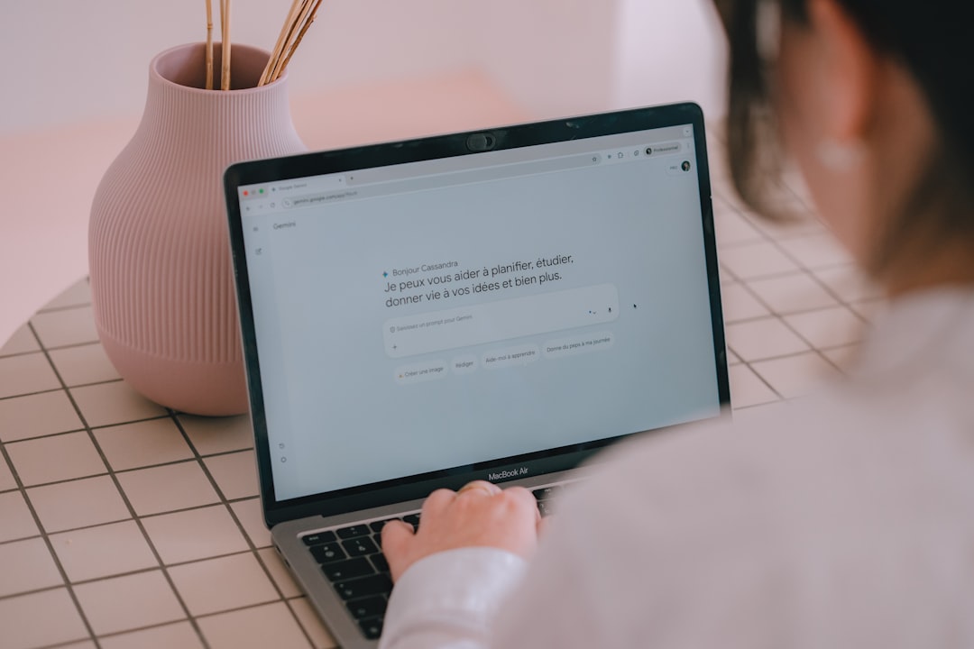 woman typing on a laptop with a vase nearby person using ai clear prompts digital assistant