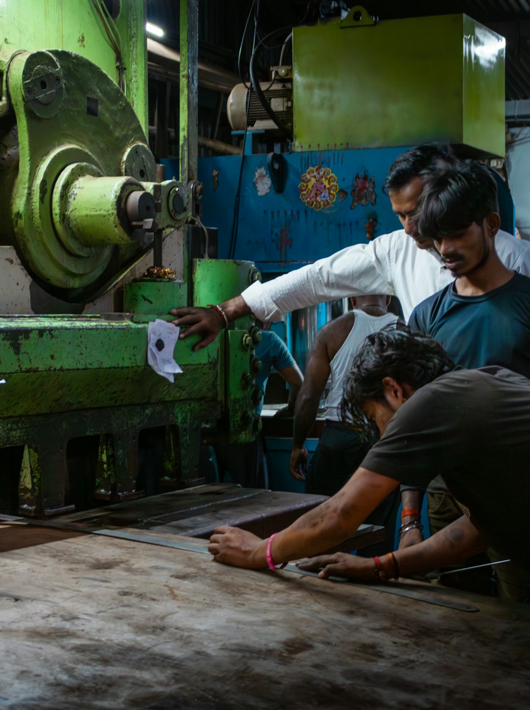 workers operating heavy machinery in a factory industrial 3d printing engineered parts manufacturing facility