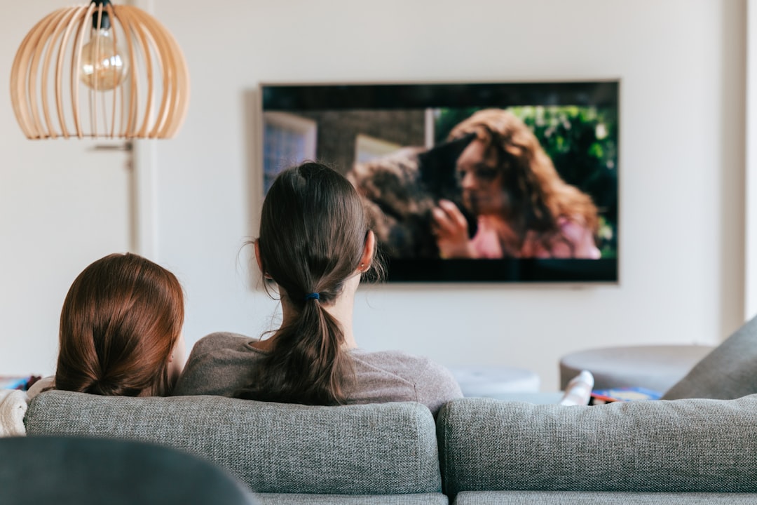 a couple of women sitting on top of a couch connected tv audience targeting media planning