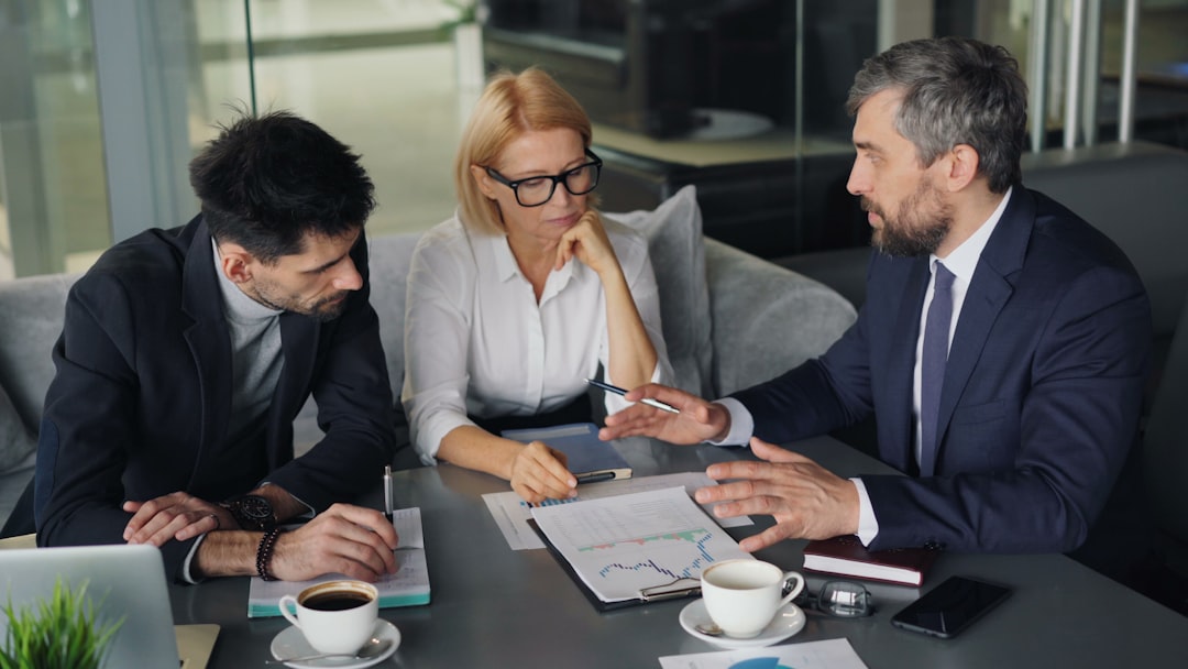 a group of people sitting around a table business consultation price discussion professional meeting