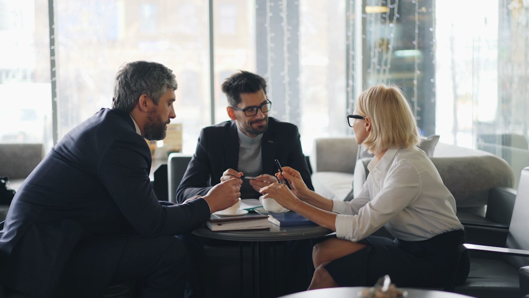 a group of people sitting around a table negotiation quote sales representative business buyer