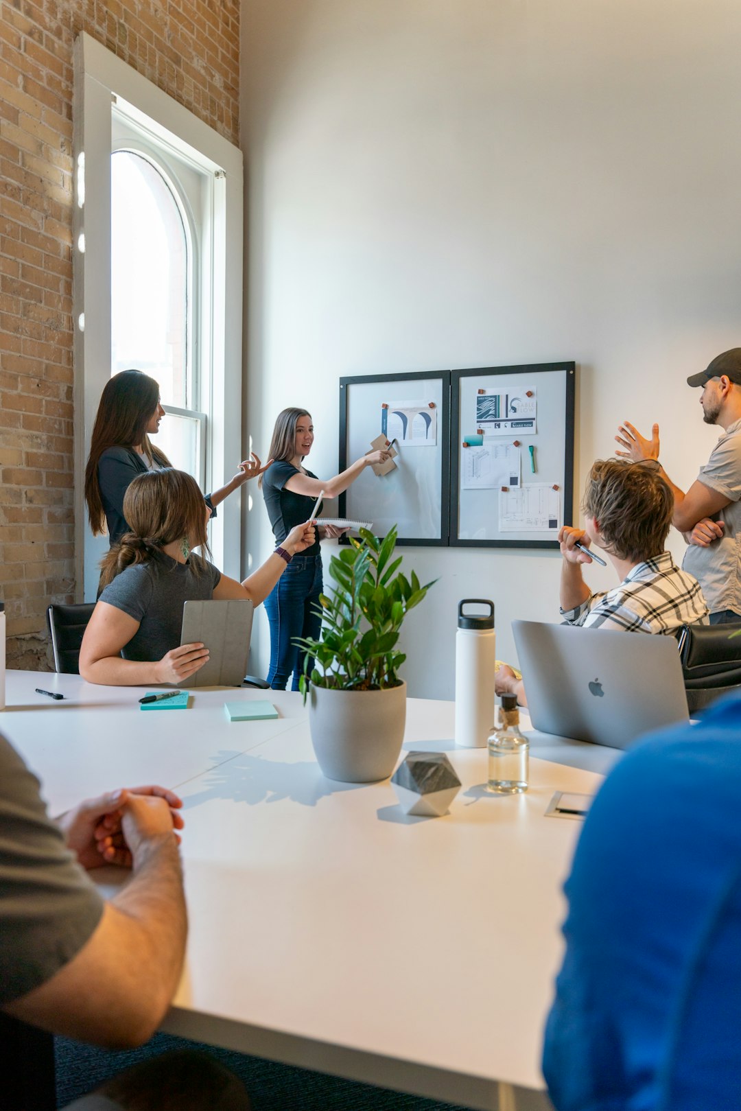 a group of people sitting around a white table software team ecommerce planning office
