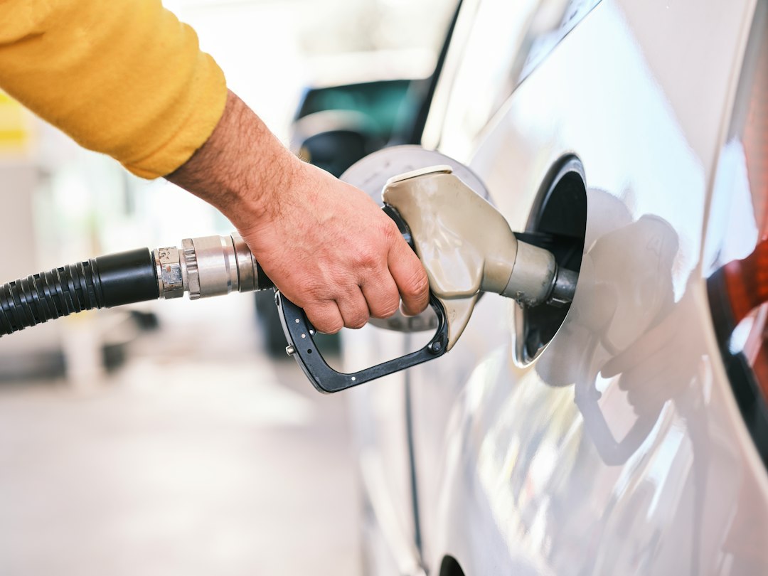 a man pumping gas into his car at a gas station driver fuel pump mobile savings
