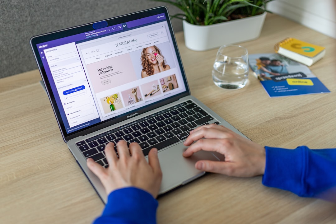 a person typing on a laptop on a table ecommerce website laptop shopping cart