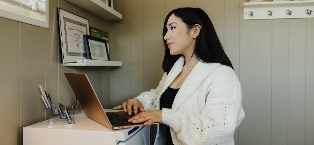 a woman sitting at a desk using a laptop computer small business owner laptop chat bubbles