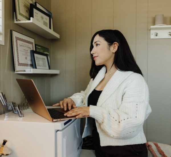 Top 7 Live Chat Software Solutions for Small Businesses in 2026 8 a woman sitting at a desk using a laptop computer small business owner laptop chat bubbles
