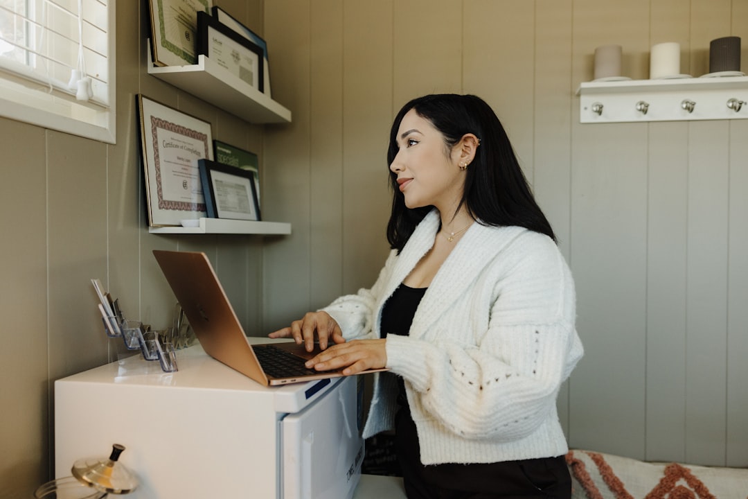 a woman sitting at a desk using a laptop computer small business owner laptop chat bubbles