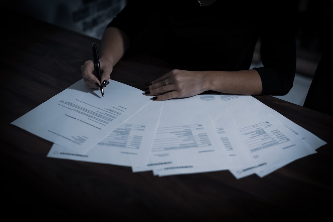 a woman sitting at a table with lots of papers ocr document scanning invoice data finance team