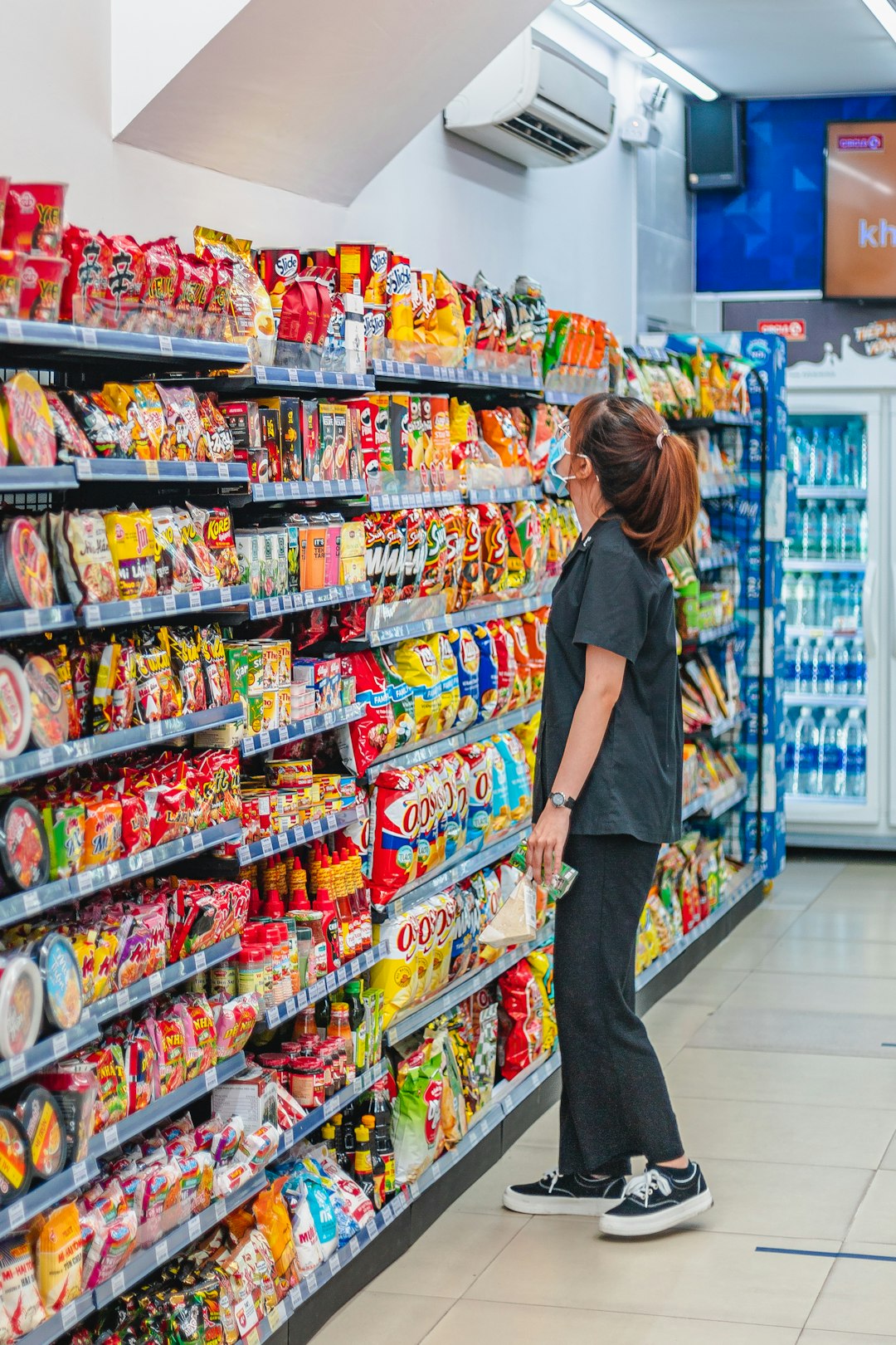a woman standing in front of a display of food shopper inspecting product discount finds retail bargains
