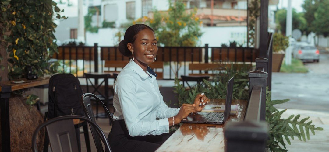 a woman working on a laptop at an outdoor cafe small business owner laptop chat bubbles