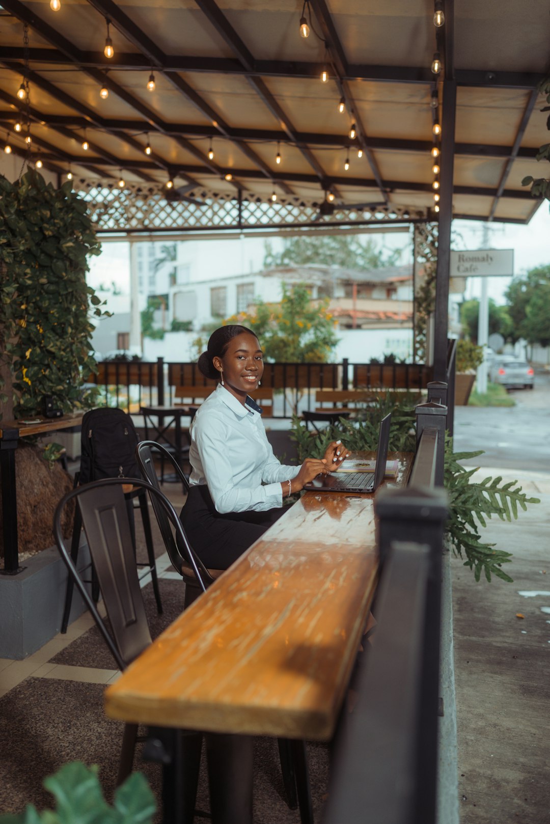 a woman working on a laptop at an outdoor cafe small business owner laptop chat bubbles