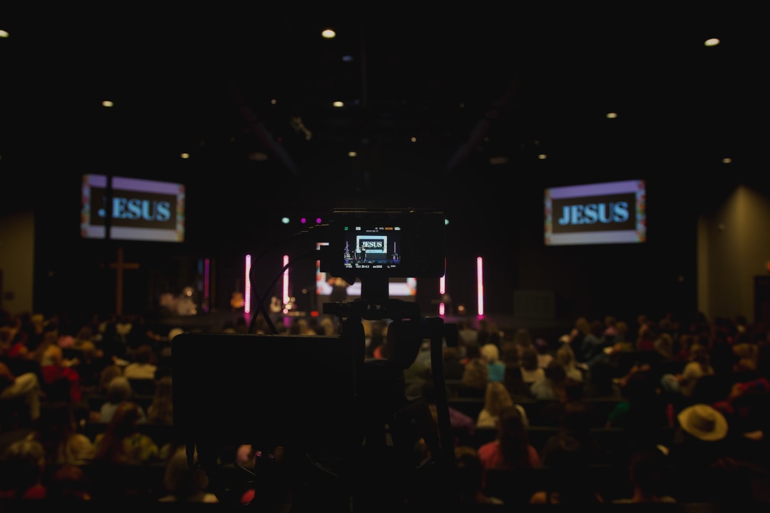 congregation watches screens displaying the word jesus local networking community event business links