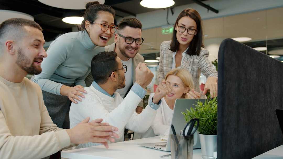 diverse team celebrating success at office desk customer support team dashboard smiling