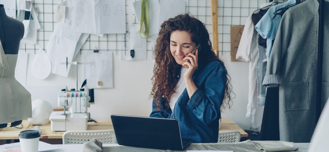 fashion designer on the phone working on a laptop small business owner laptop chat bubbles