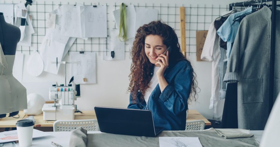 fashion designer on the phone working on a laptop small business owner laptop chat bubbles