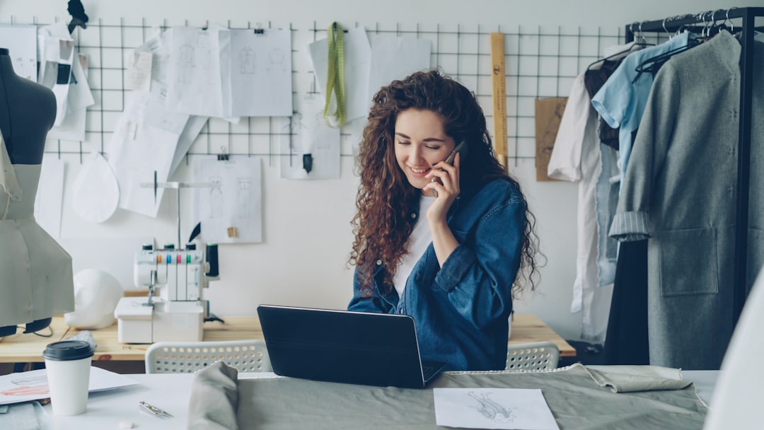 fashion designer on the phone working on a laptop small business owner laptop chat bubbles