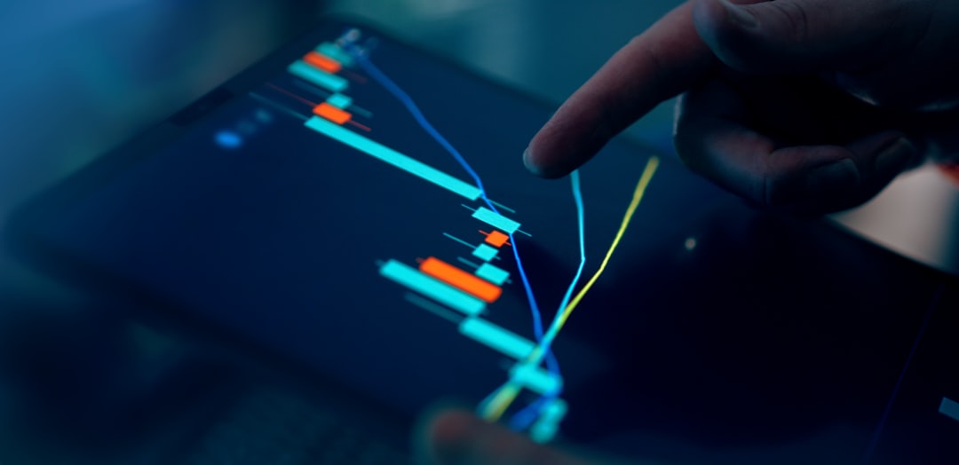 fingers interacting with a stock market graph on a tablet property investment map capital flows global markets