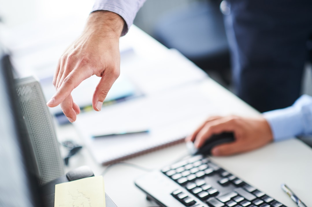 hands pointing at computer monitor while operating mouse and keyboard online fax business documents digital office