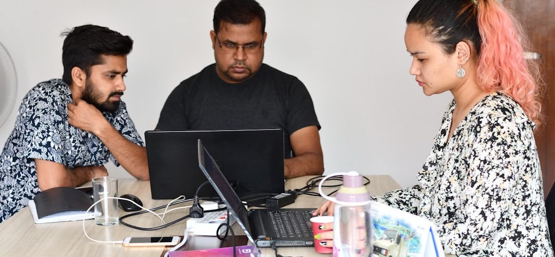man in black crew neck t shirt sitting beside woman in black and white floral dress customer support problem solving professional team